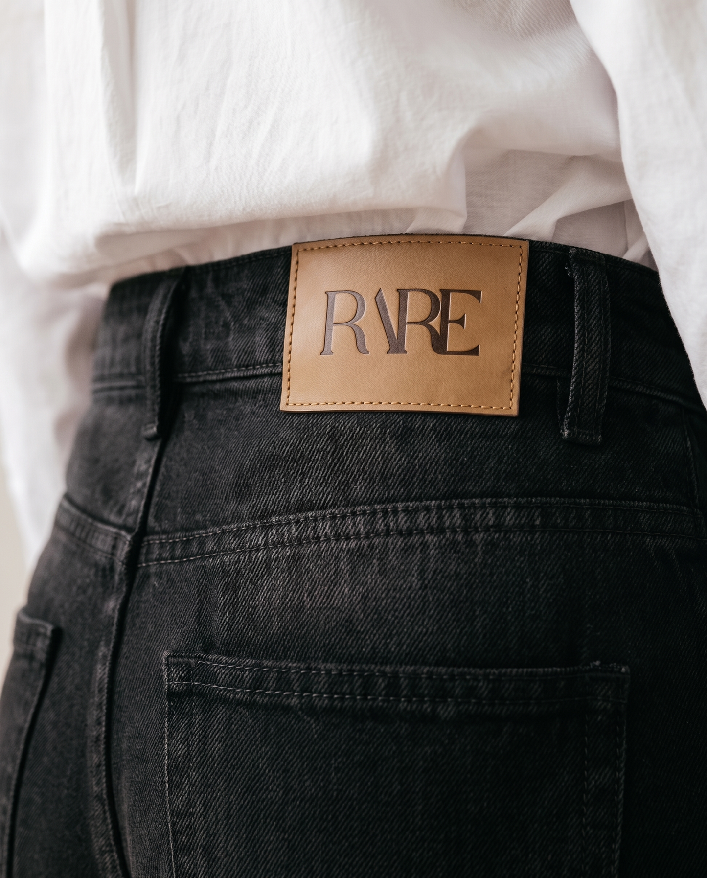 RARE Onyx jeans, solid black back waistband detail with the tan leather RARE patch
